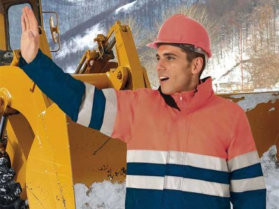 Homem com casaco de proteção laranja e capacete rosa junto a máquina amarela na neve