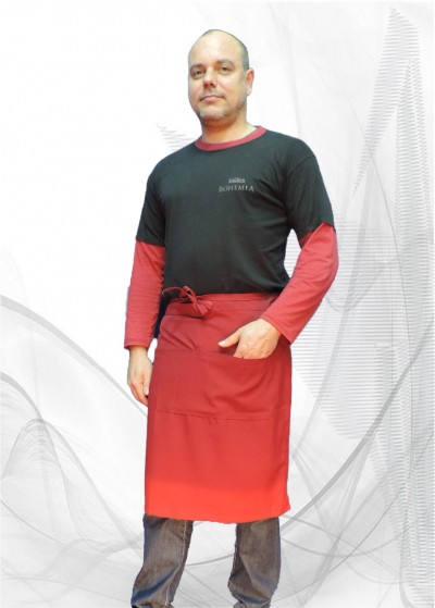 Homem com t-shirt preta e vermelha, avental vermelho e calças jeans em fundo branco com linhas cinzentas