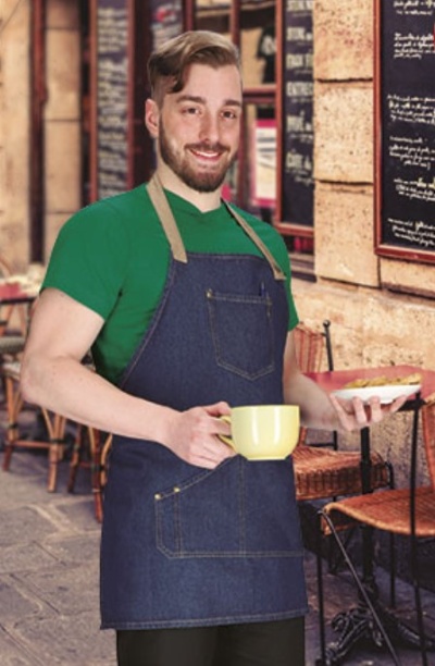 Homem com avental de ganga e camiseta verde segurando chávena amarela numa esplanada