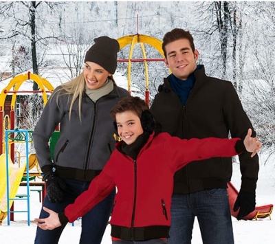 Três pessoas com casacos de inverno em parque infantil nevado