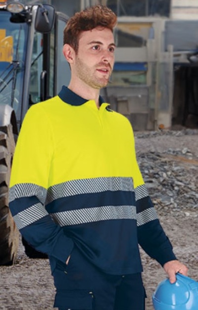 Homem com camisa de trabalho amarelo fluorescente e azul escuro com riscas refletoras e capacete azul em construção