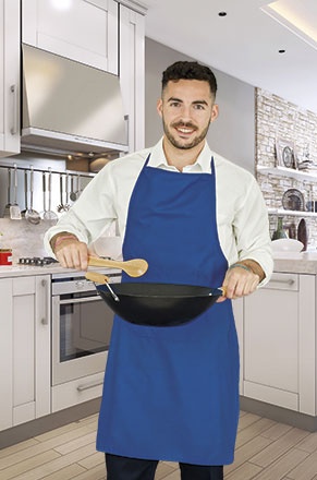 Homem em avental azul segurando frigideira na cozinha moderna