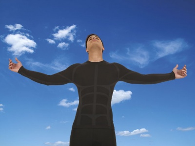 Homem com camisa térmica preta e braço aberto sob céu azul