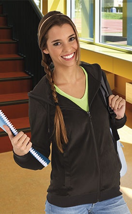 Jovem com casaco preto, caderno e mochila em ambiente interior