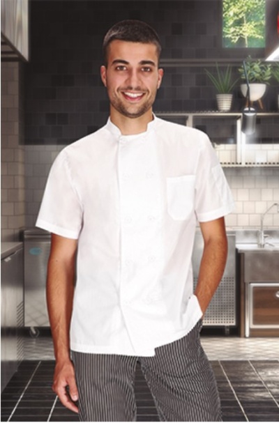 Homem com camisa branca de chef e calças listradas numa cozinha profissional moderna