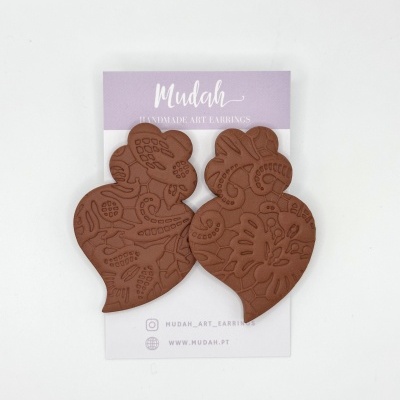 Brincos de argila castanha com padrões florais em cartão de embalagem lilás e branco