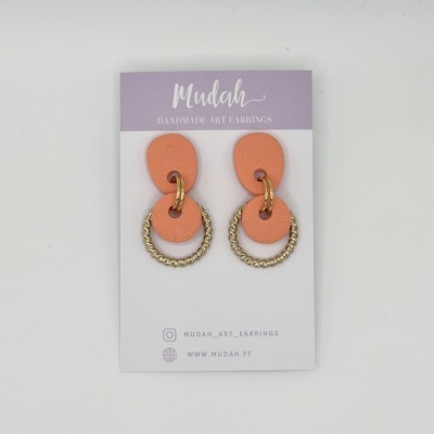 Brincos handmade laranja e dourado em cartaz lilás e branco