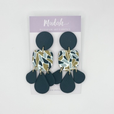 Brincos artesanais azuis com padrão abstrato pendurados em cartão