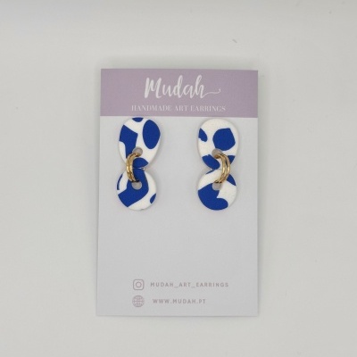 Brincos artesanais azul e branco com argolas douradas, em cartão Mudah lilás e branco