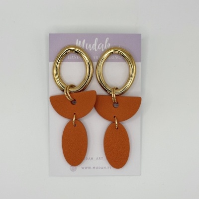 Brincos com argolas douradas e pendentes laranja em cartão de apresentação