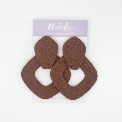 Brincos artesanais castanhos texturizados em suporte lilás