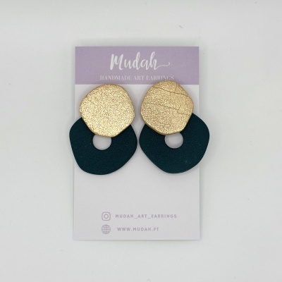 Brincos dourados e pretos da marca Mudah apresentados em cartão lilás e branco