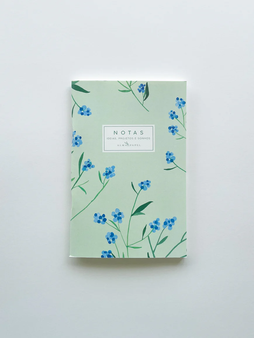 Caderno de capa verde clara com flores azuis e texto central