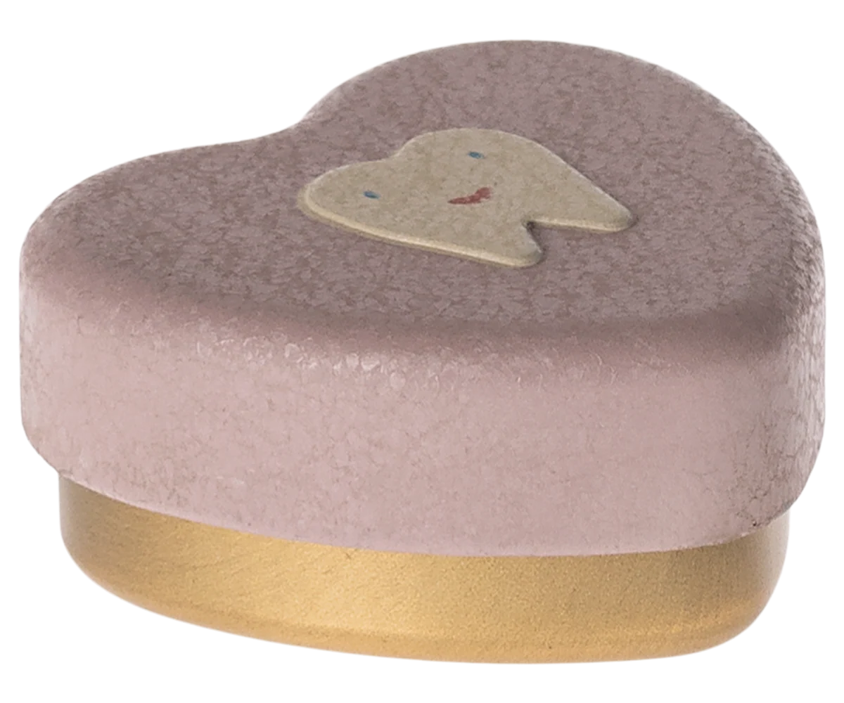 Escova de dentes em forma de coração cor-de-rosa com dente sorridente