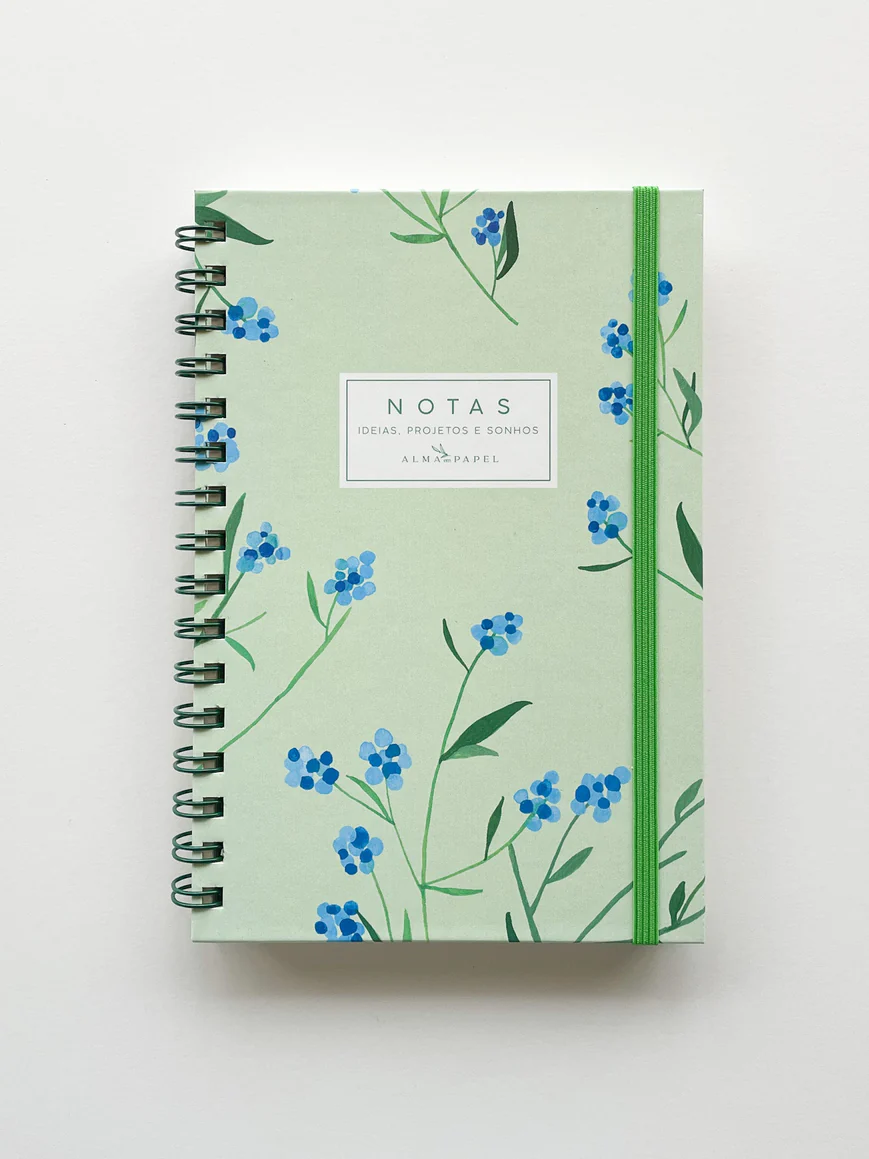 Caderno verde claro com flores azuis, espiral e elástico verde