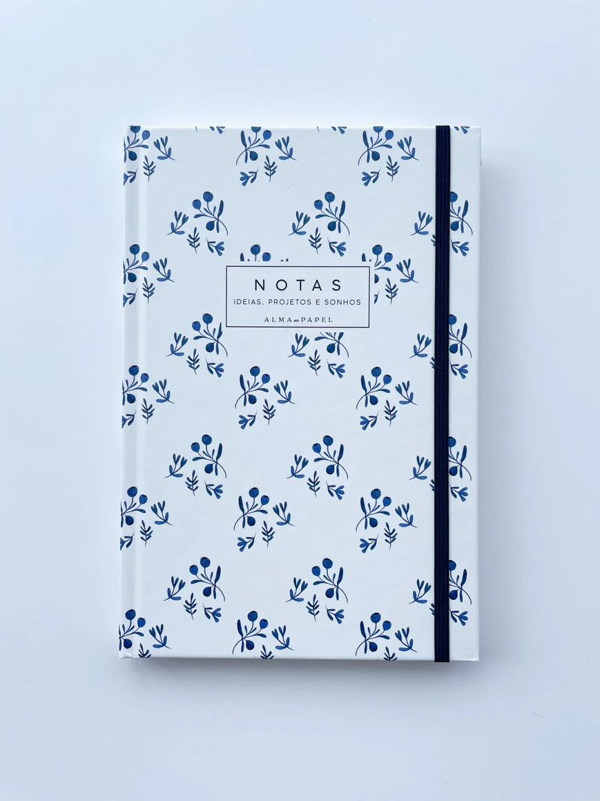 Caderno branco com padrão floral azul e elástico preto na lateral