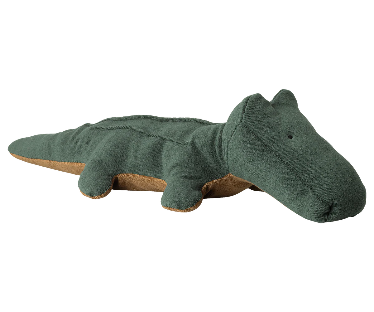 Pelúcia verde de crocodilo em fundo neutro claro