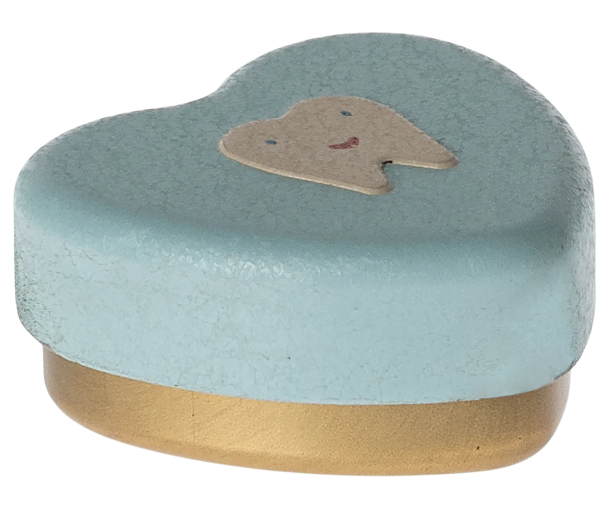 Caixa de metal azul claro com tampa em forma de dente sorridente