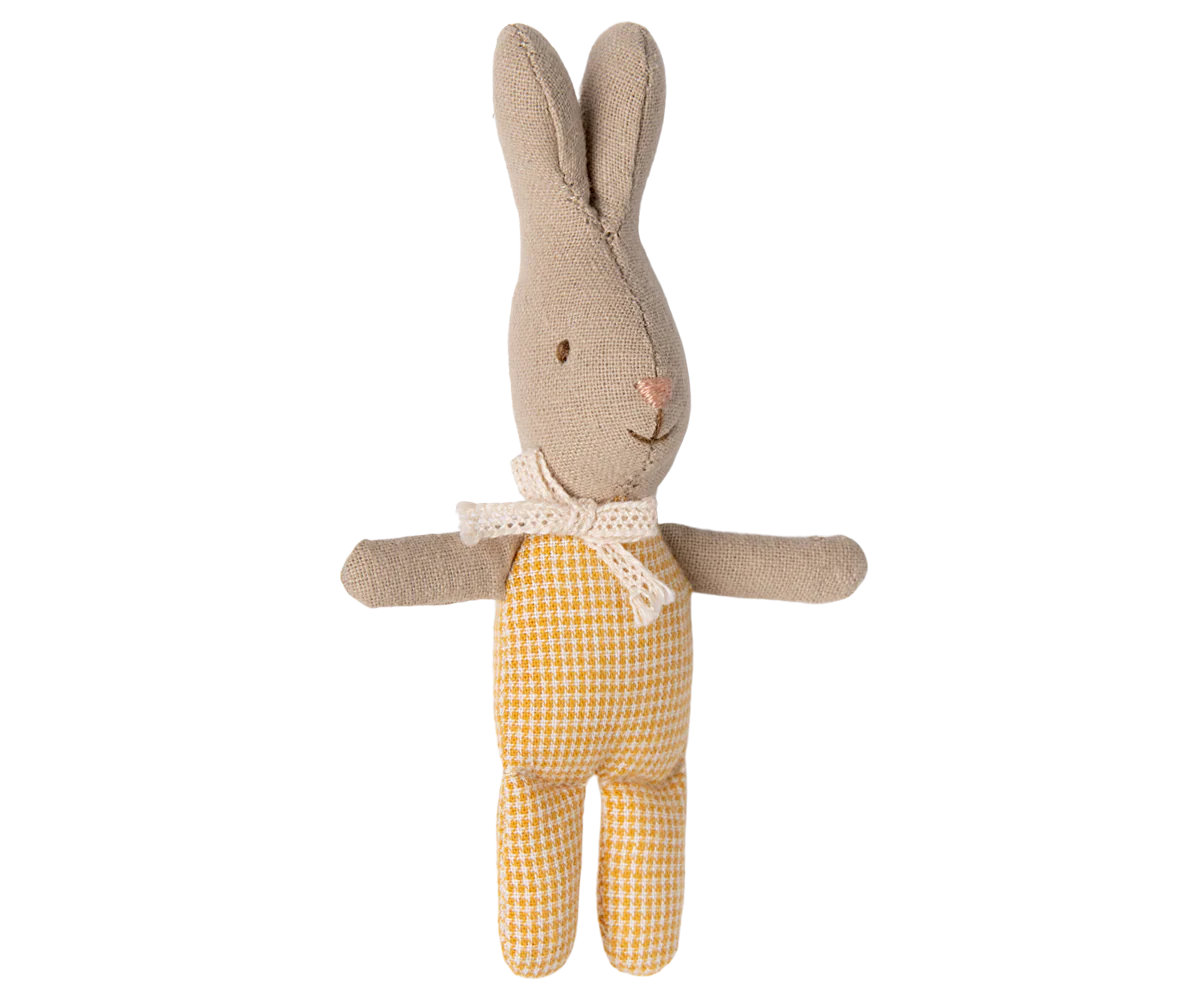 Boneco de coelho de tecido bege com corpo amarelo xadrez e laço branco