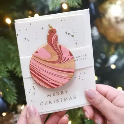 Cartão de Natal com pendente decorativo em madeira e texto Merry Christmas