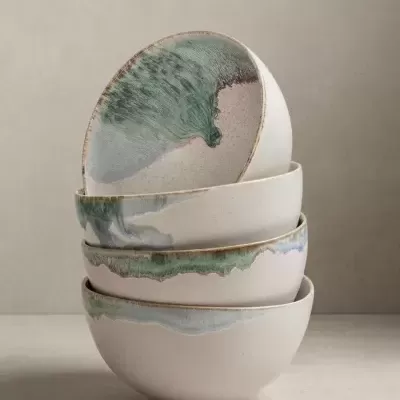 Conjunto de quatro tigelas de cerâmica branca com acabamento esmaltado colorido empilhadas