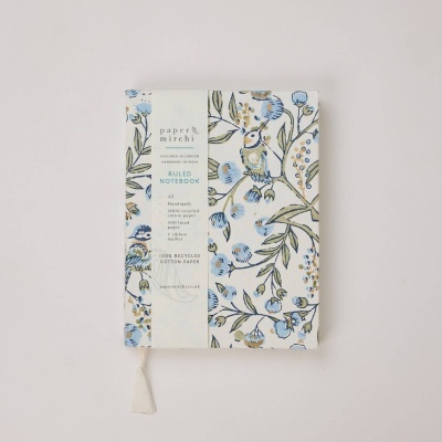 Caderno decorado com padrão floral e pássaros e etiqueta com texto