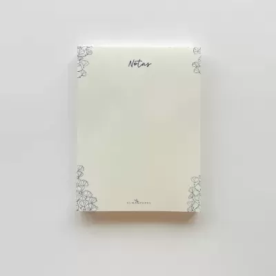 Bloco de notas creme com ilustrações florais azuis e texto Notas e ALMA PAPEL