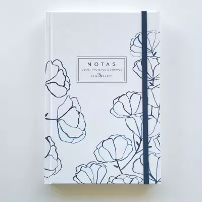 Caderno branco com desenhos florais azuis e texto central com elástico azul.