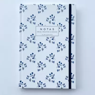 Caderno branco com padrão floral azul e elástico preto na lateral