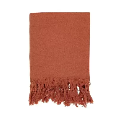 Manta de tecido terracota com franjas entrelaçadas