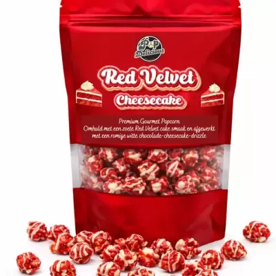 Pacote vermelho de pipocas Red Velvet Cheesecake da Pop Delicious com pipocas vermelhas e brancas em redor.