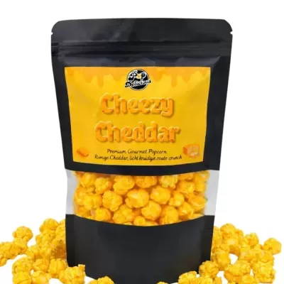 Pacote preto de pipocas gourmet Cheezy Cheddar com selo amarelo
