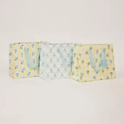 Três bolsas têxteis coloridas com padrões florais e alças azuis