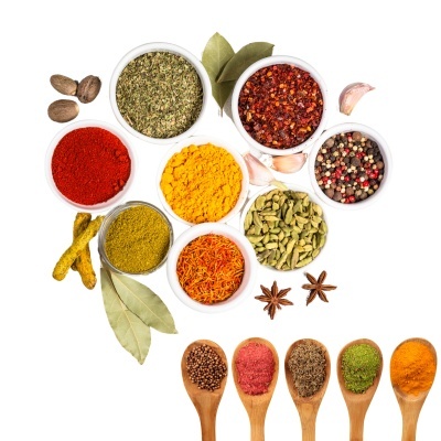Especiarias variadas em tigelas e colheres de madeira sobre fundo branco