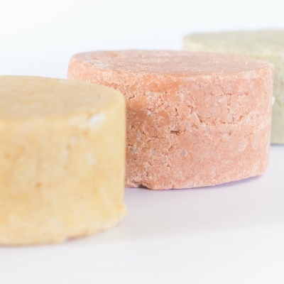 Três sólidos coloridos redondos dispostos em fila sobre superfície branca