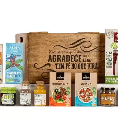 Conjunto de produtos alimentares variados em embalagens coloridas com caixa de madeira com texto ao centro