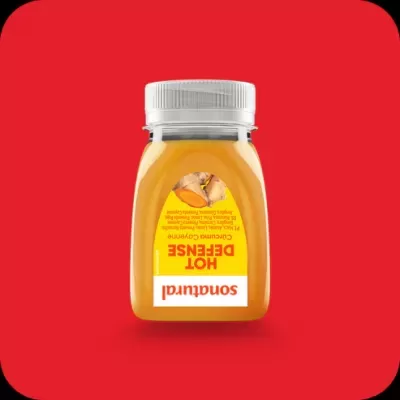 Frasco de molho amarelo Sonatural Hot Defense com tampa branca em fundo vermelho