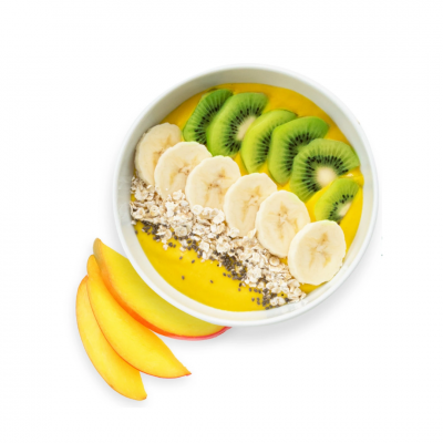 Tigela branca com smoothie amarelo coberto por kiwi, banana, aveia e sementes e fatias de pêssego ao lado