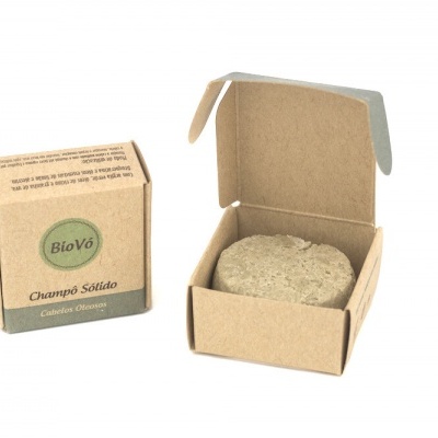 Sabonete sólido bege em embalagem de cartão castanho com texto BioVó, Champô Sólido, Camomila e Aveia