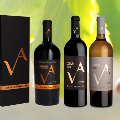 Três garrafas de vinho com rótulos VA e uma caixa preta com inscrição Reserva Especial sobre fundo natural.