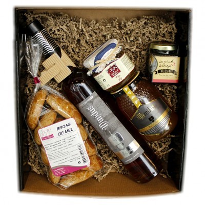 Conjunto de produtos artesanais numa caixa de presente com broas de mel, licor, compota, mel e decoração de palha