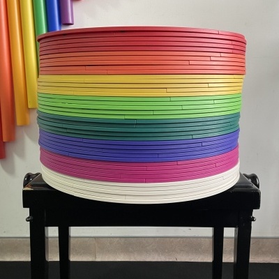 Objetos empilhados coloridos em faixas horizontais sobre superfície preta