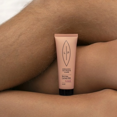 Tubo cor de rosa com produto cosmético LP em pele humana