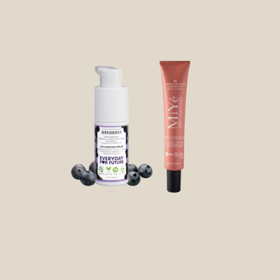 Dois produtos de beleza, um frasco com rótulo branco e lilás e um tubo metálico rosa