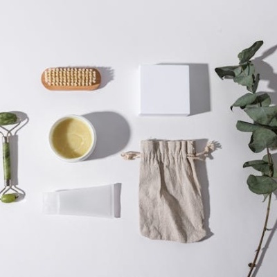 Conjunto de produtos de cuidados pessoais com rolo de jade, escova, creme, saco de algodão e rama de eucalipto