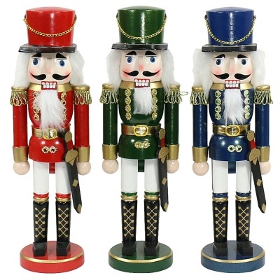 Três figuras de soldado Quebra-Nozes em madeira, vestidas com uniformes vermelho, verde e azul
