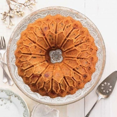 Bolo bundt castanho decorativo num prato transparente