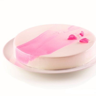 Bolo redondo com cobertura branca e detalhes rosa, com pétalas decorativas no topo.