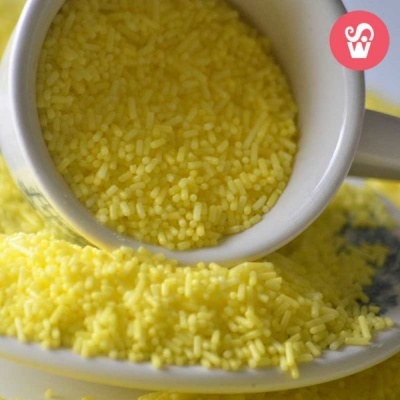 Grânulos amarelos pequenos em chávena e prato branco