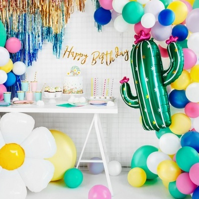 Decoração de festa de aniversário com balões coloridos e bolo numa mesa branca